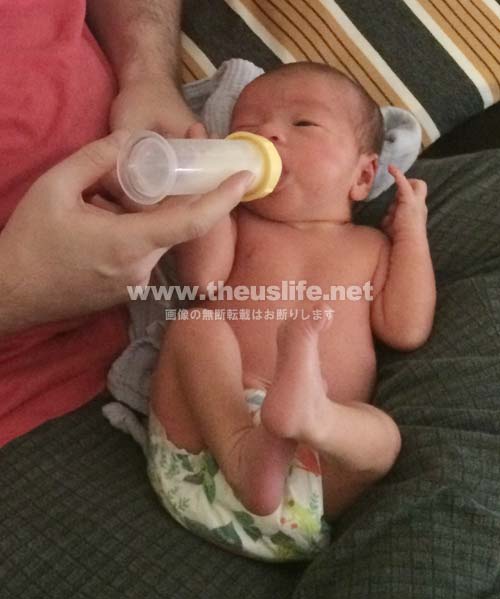 生後一週間の日米ハーフの一重まぶたの赤ちゃんの顔。片目だけ閉じている。