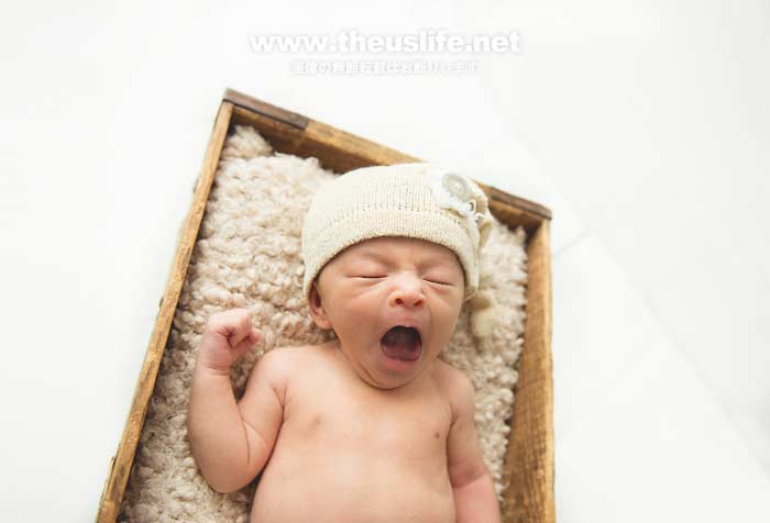 ニューボーンフォトで撮影した箱に入った赤ちゃんがあくびしてる写真